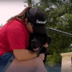 Woman in red shirt hugging a dog