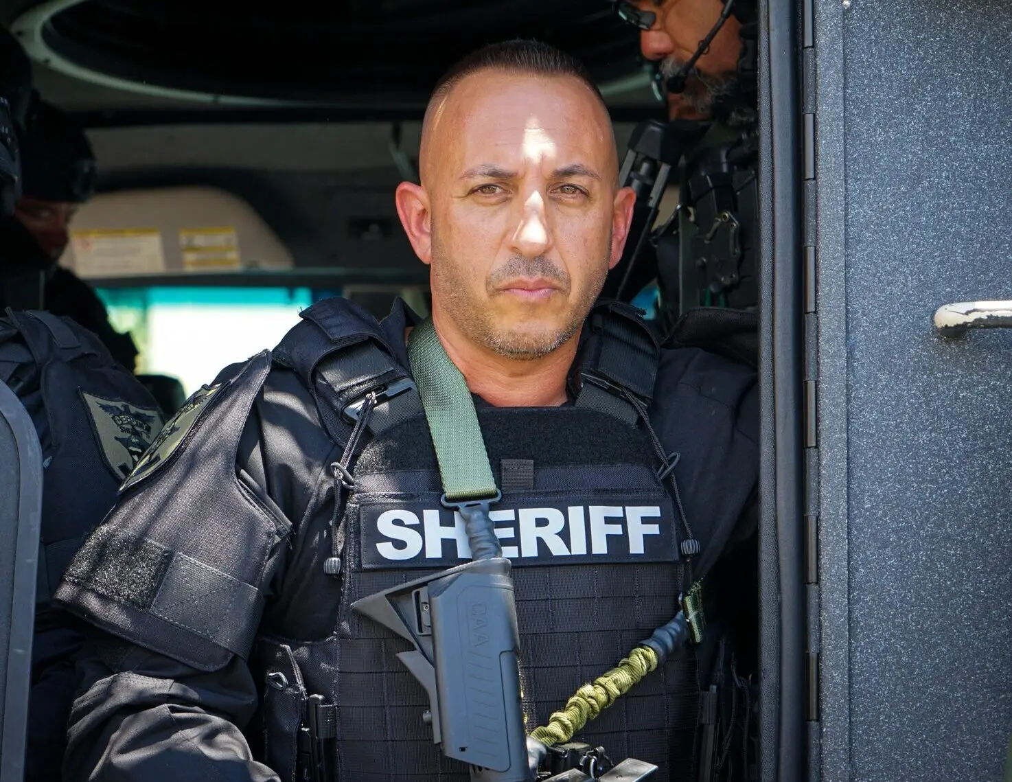 Sheriff Marceno in military gear on a helicopter.